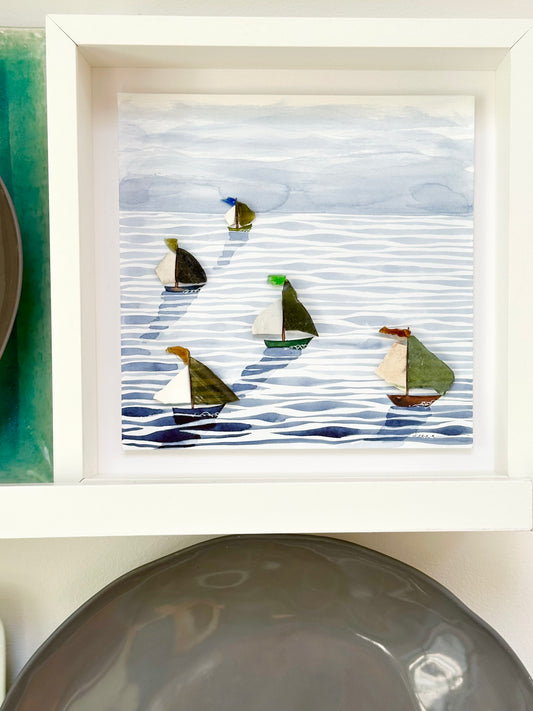 “Mixed media coastal artwork with watercolour waves and sailboats made from reclaimed china shards in a white frame.”