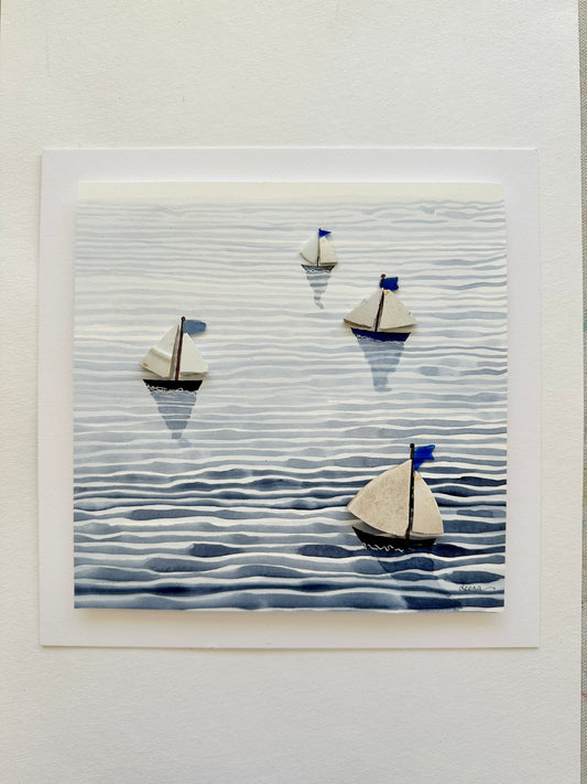 “Mixed media coastal artwork with watercolour waves and sailboats made from reclaimed china shards in a white frame.”