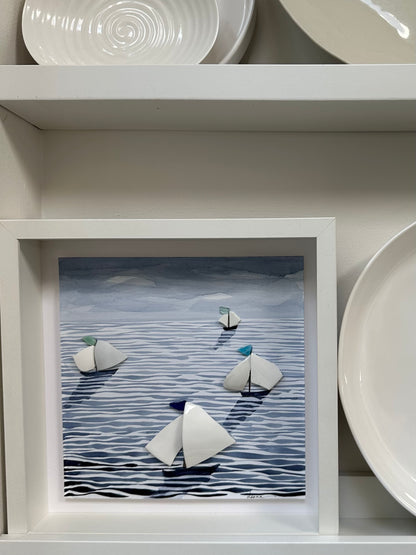 “Mixed media coastal artwork with watercolour waves and sailboats made from reclaimed china shards in a white frame.”