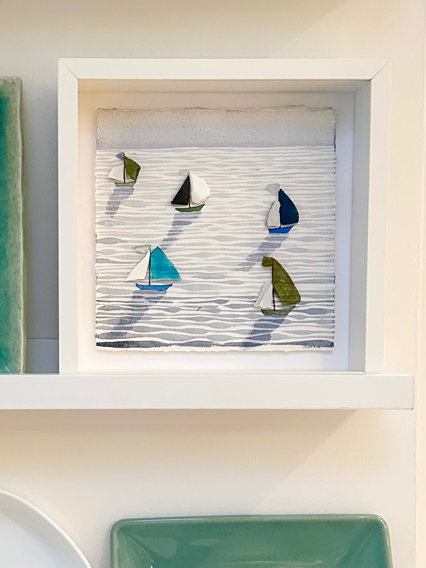 “Mixed media coastal artwork with watercolour waves and sailboats made from reclaimed china shards in a white frame.”